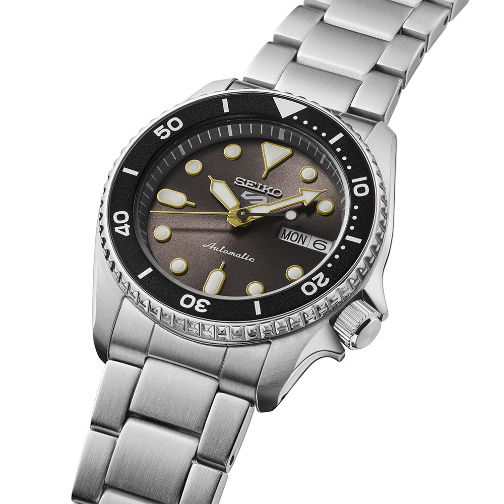 Seiko 5 Sports SRPL79K1 close-up showing grey dial with gold-toned hands and darker grey bezel