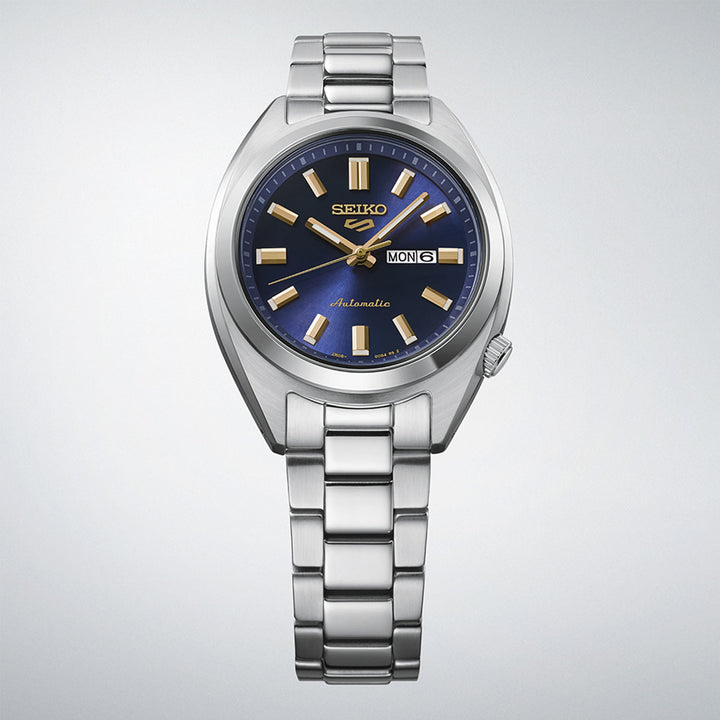 Seiko 5 Sports SRE021K1 navy dial automatic watch displayed upright on gradient grey background, showing full case and bracelet profile