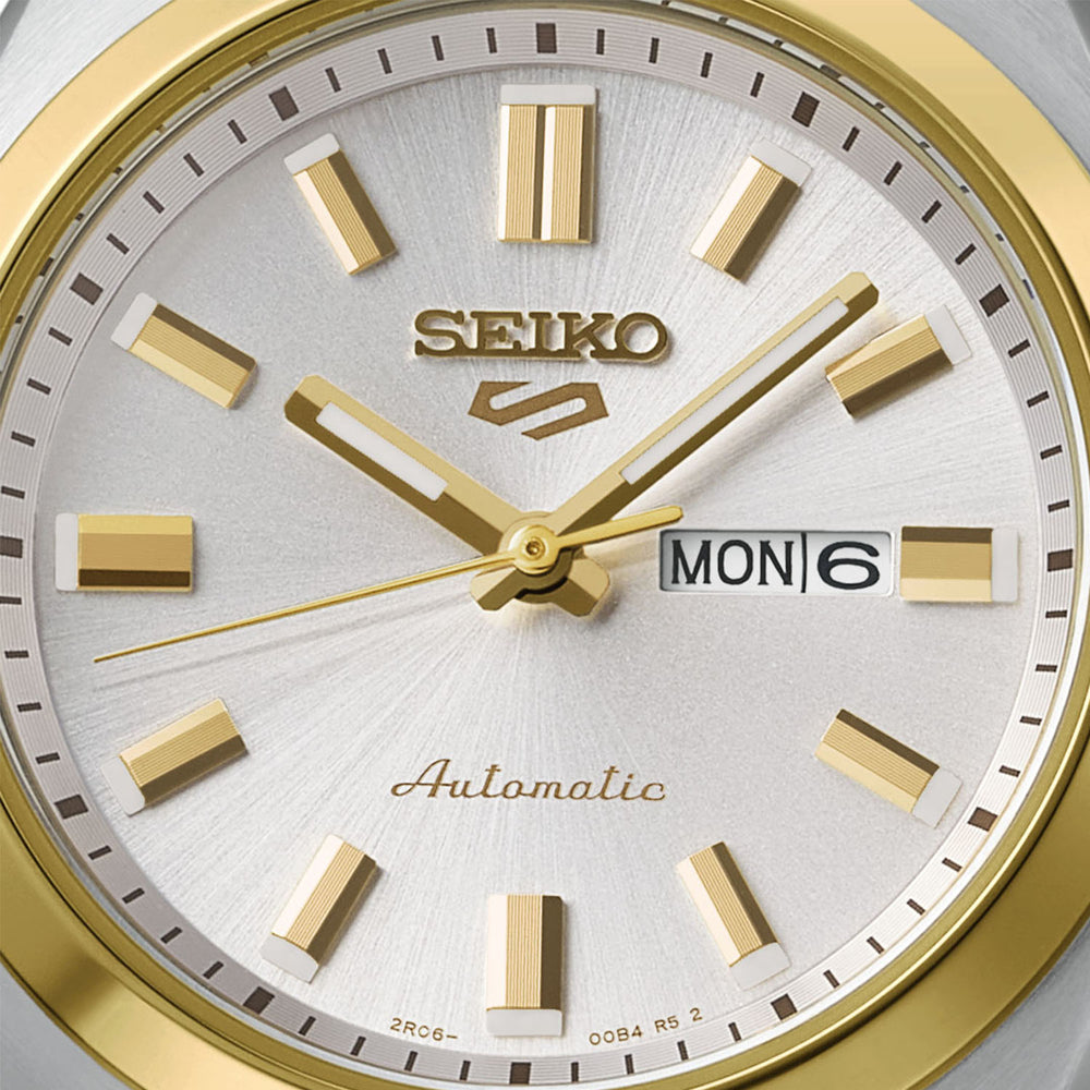 Seiko 5 Sports SRE024K1 32mm automatic women's watch dial close-up — silver sunray dial with gold baton indices and hands, day-date display showing MON 6, gold-tone bezel