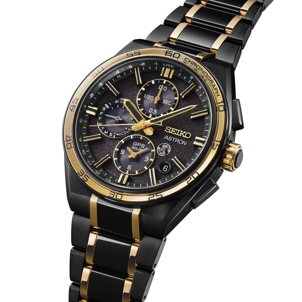 Seiko Astron SSH186J1 44.1mm GPS solar chronograph — black textured dial with gold accents, gold-tone bezel, black and gold two-tone titanium bracelet, 3/4 angle view