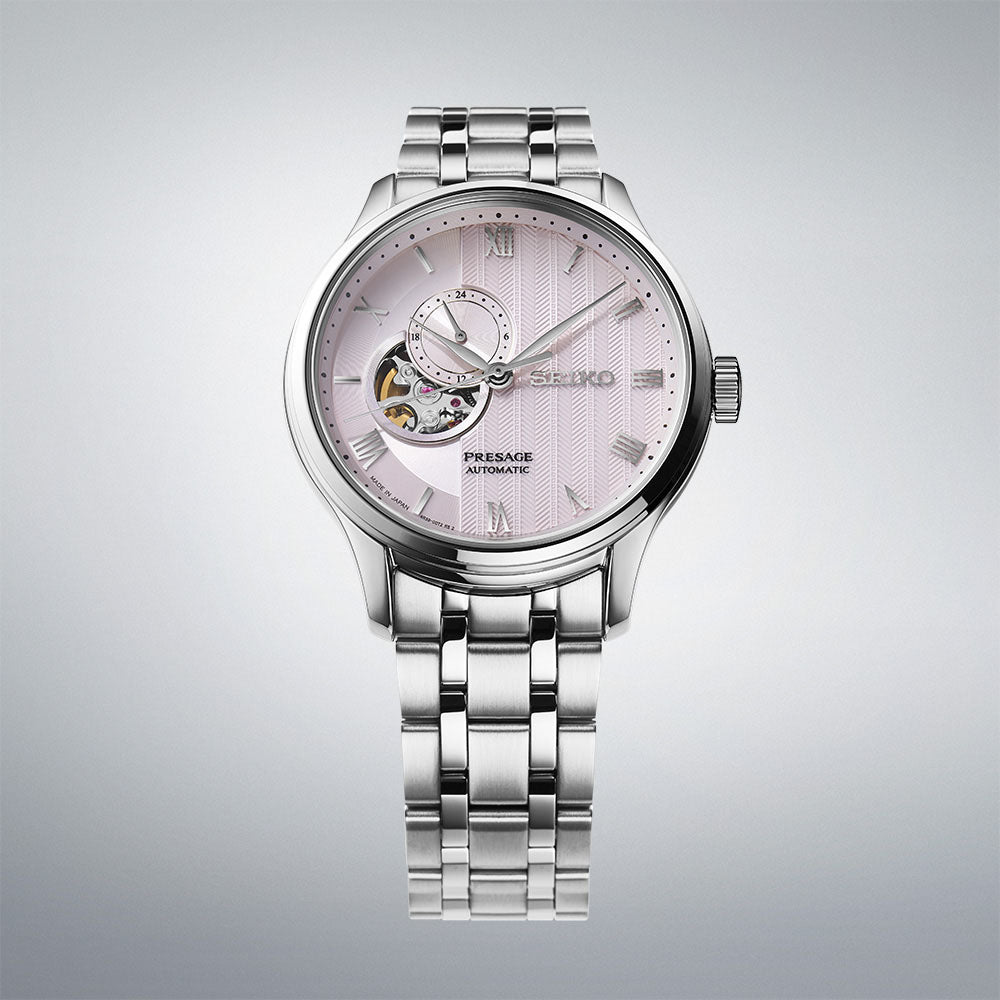 Seiko Presage SSA465J1 close-up showing pale pink dial with Roman numerals and dual-curved sapphire