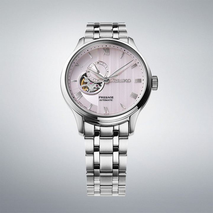 Seiko Presage SSA465J1 close-up showing pale pink dial with Roman numerals and dual-curved sapphire