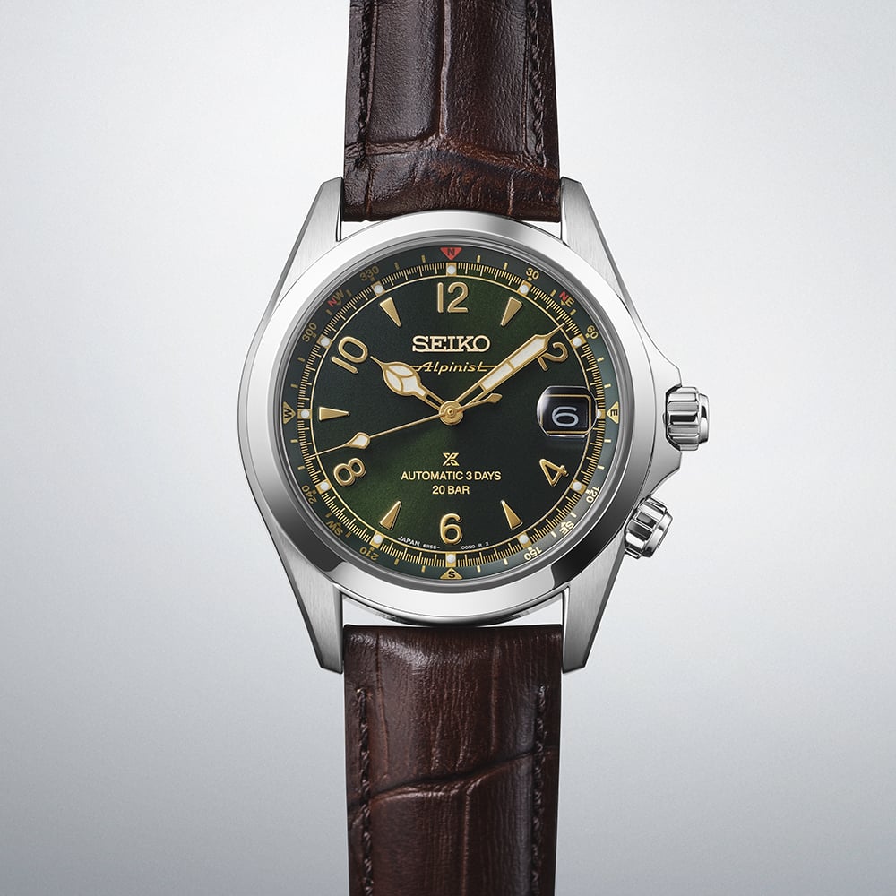 Seiko Prospex Alpinist SPB507J1 — close angled view on gradient grey background highlighting the green dial with gold Arabic numerals, inner compass ring, and dual crown pusher detail