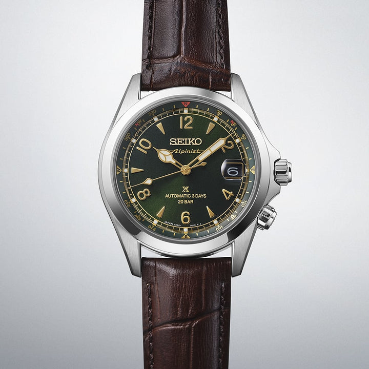 Seiko Prospex Alpinist SPB507J1 — close angled view on gradient grey background highlighting the green dial with gold Arabic numerals, inner compass ring, and dual crown pusher detail