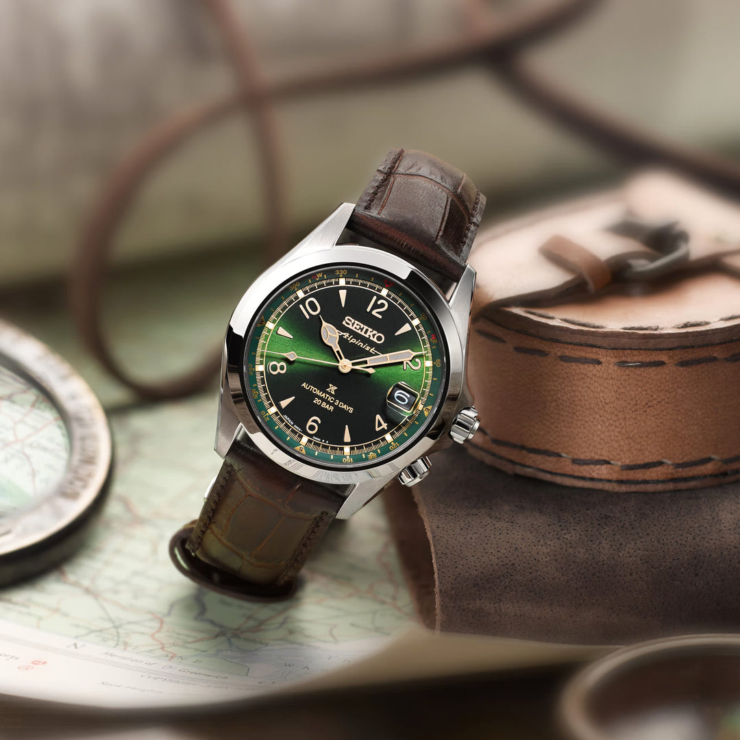 Seiko Prospex Alpinist SPB507J1 — front view on gradient grey background showing deep green dial, inner compass ring with cardinal points, and dark brown cow leather strap