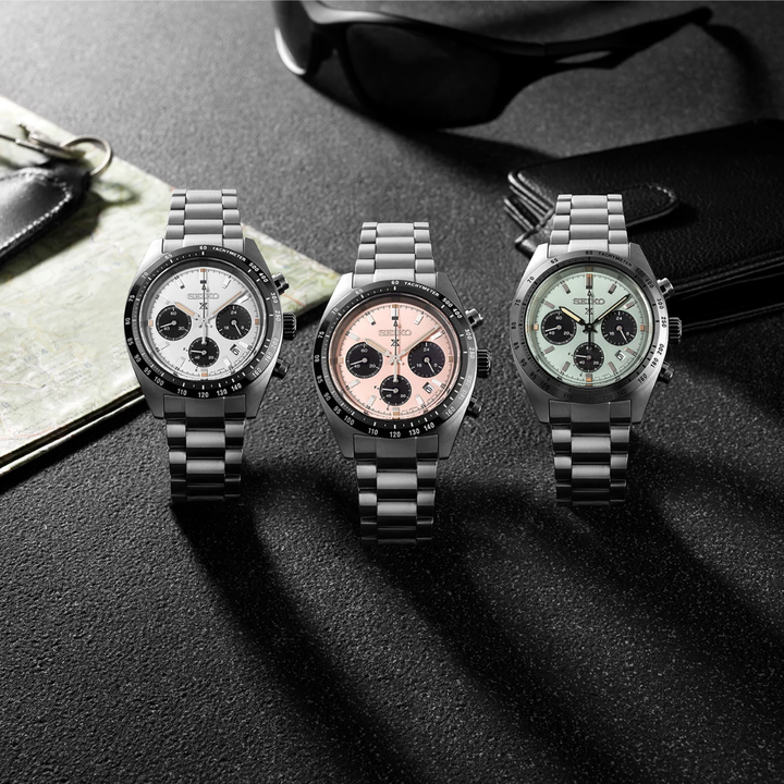 Seiko Prospex Speedtimer solar chronograph collection — white panda SSC961P1, pale pink SSC963P1, and mint green SSC965P1 with stainless steel bracelets, motorsport lifestyle shot