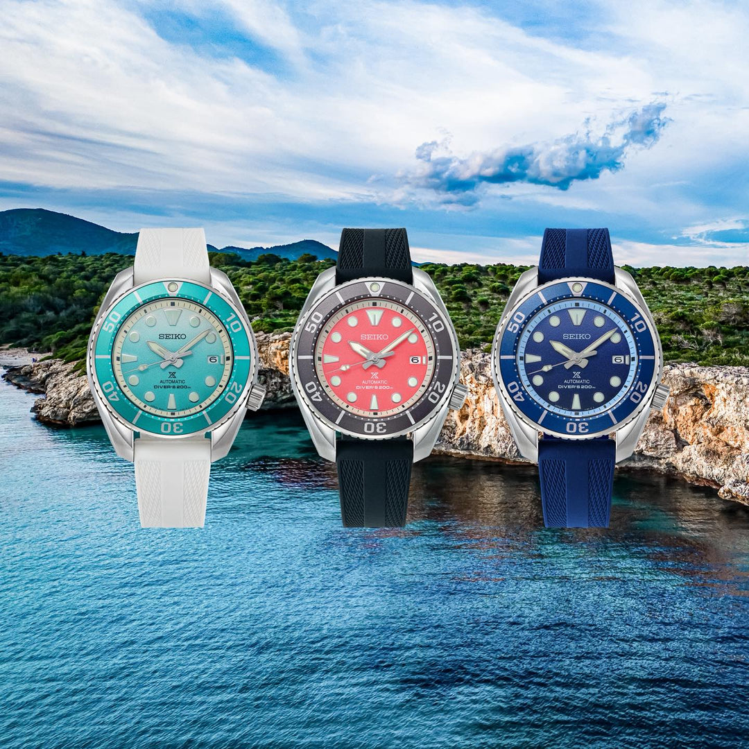 spb543j1-navy-collection-lifestyle.jpgSeiko Prospex Sumo collection — three variants displayed against a coastal seascape: teal dial with white strap, coral dial with black strap, and navy blue dial with navy strap
